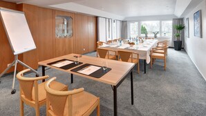 A conference room with a long table, multiple chairs, a whiteboard, and large windows. - Ringhotel Parkhotel Witten (Witten)