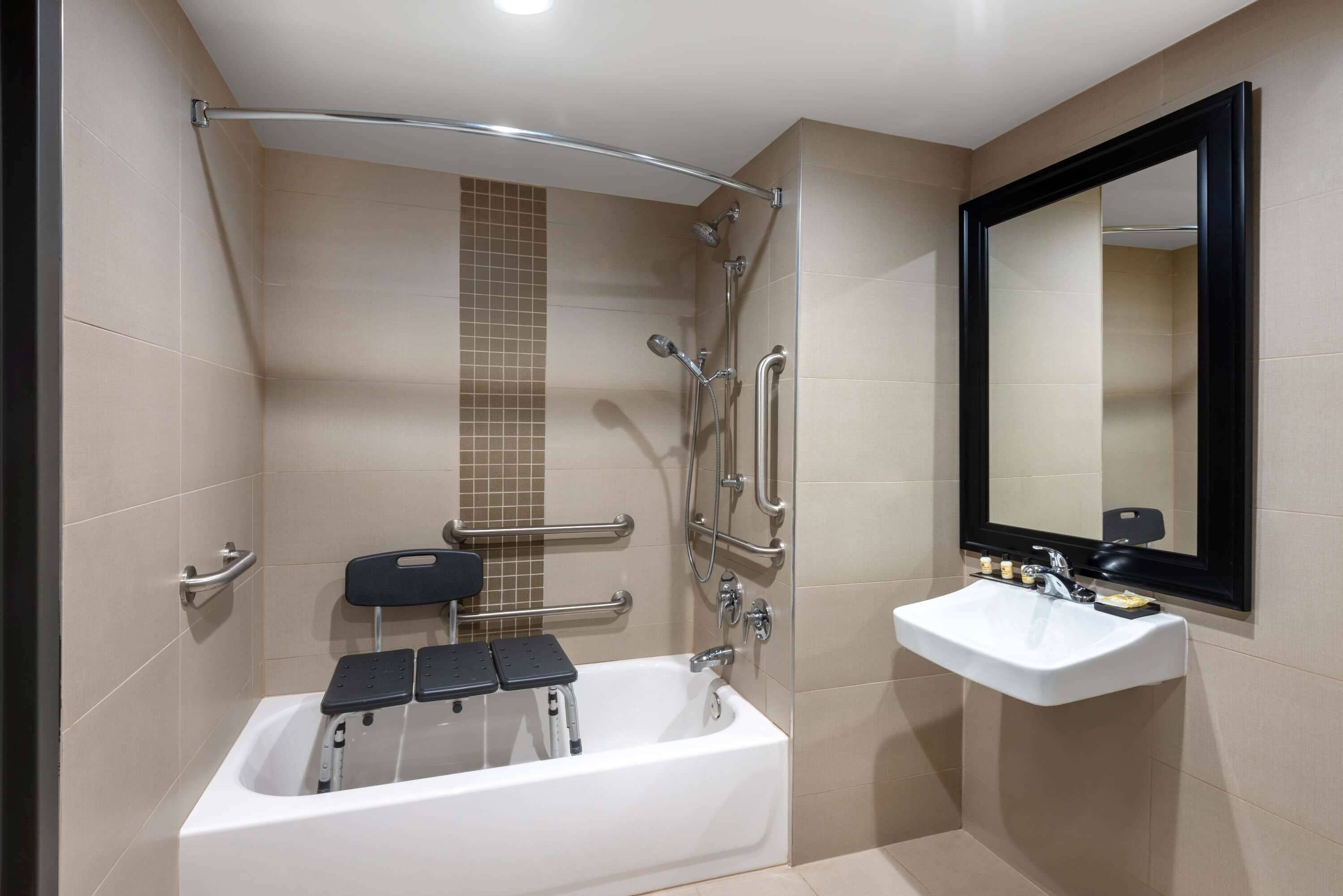 A modern bathroom with a bathtub, a sink, and a mirror.