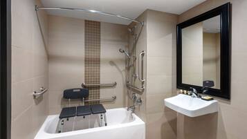 A modern bathroom with a bathtub, a sink, and a mirror.