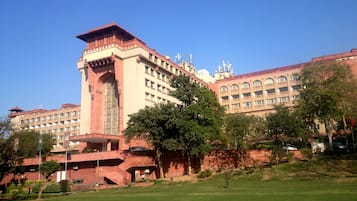 Standing tall amidst lush surroundings, this grand building showcases intricate architectural details.