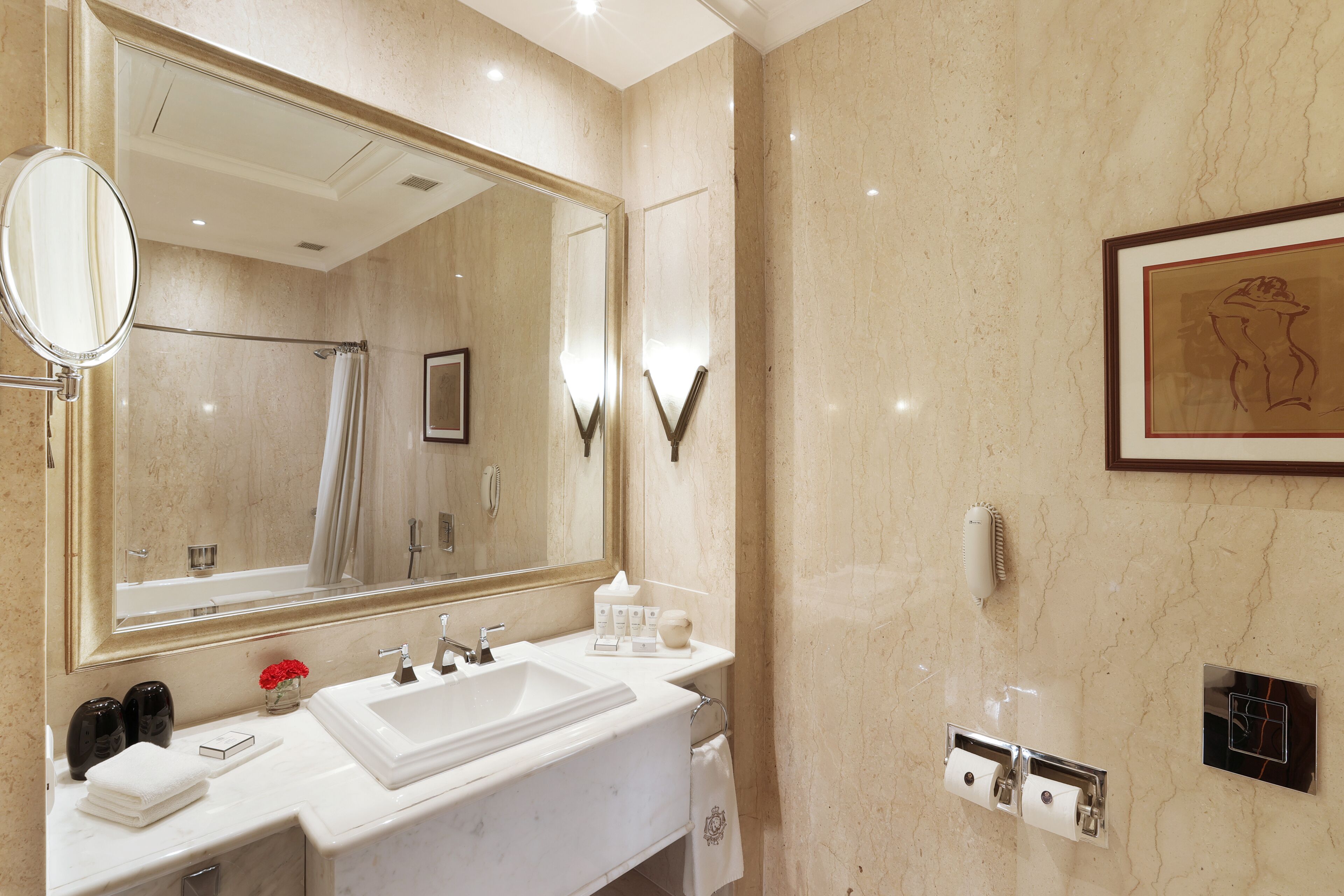 A modern bathroom with a large mirror, a sink, and a shower.