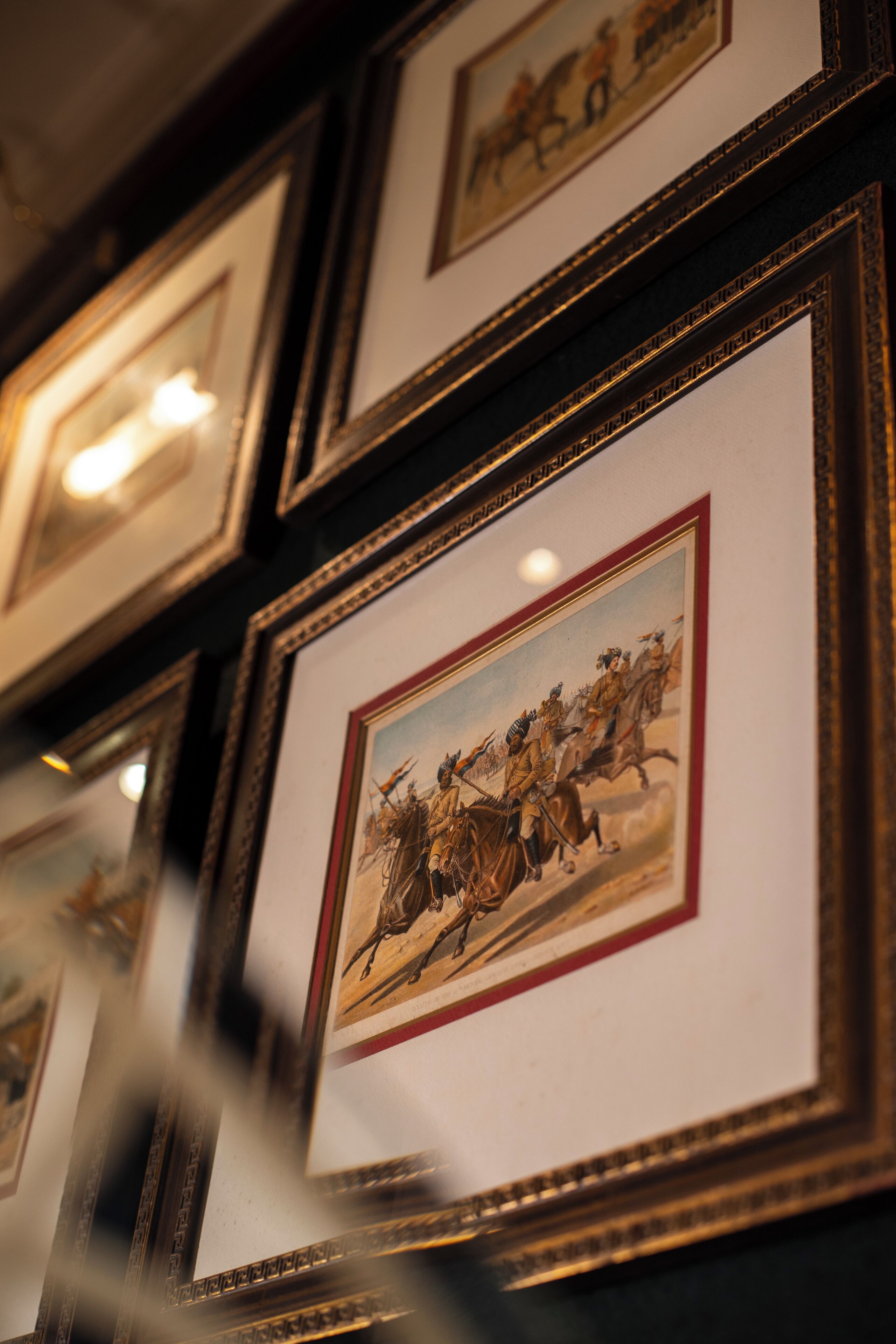 Framed historical paintings on a wall.