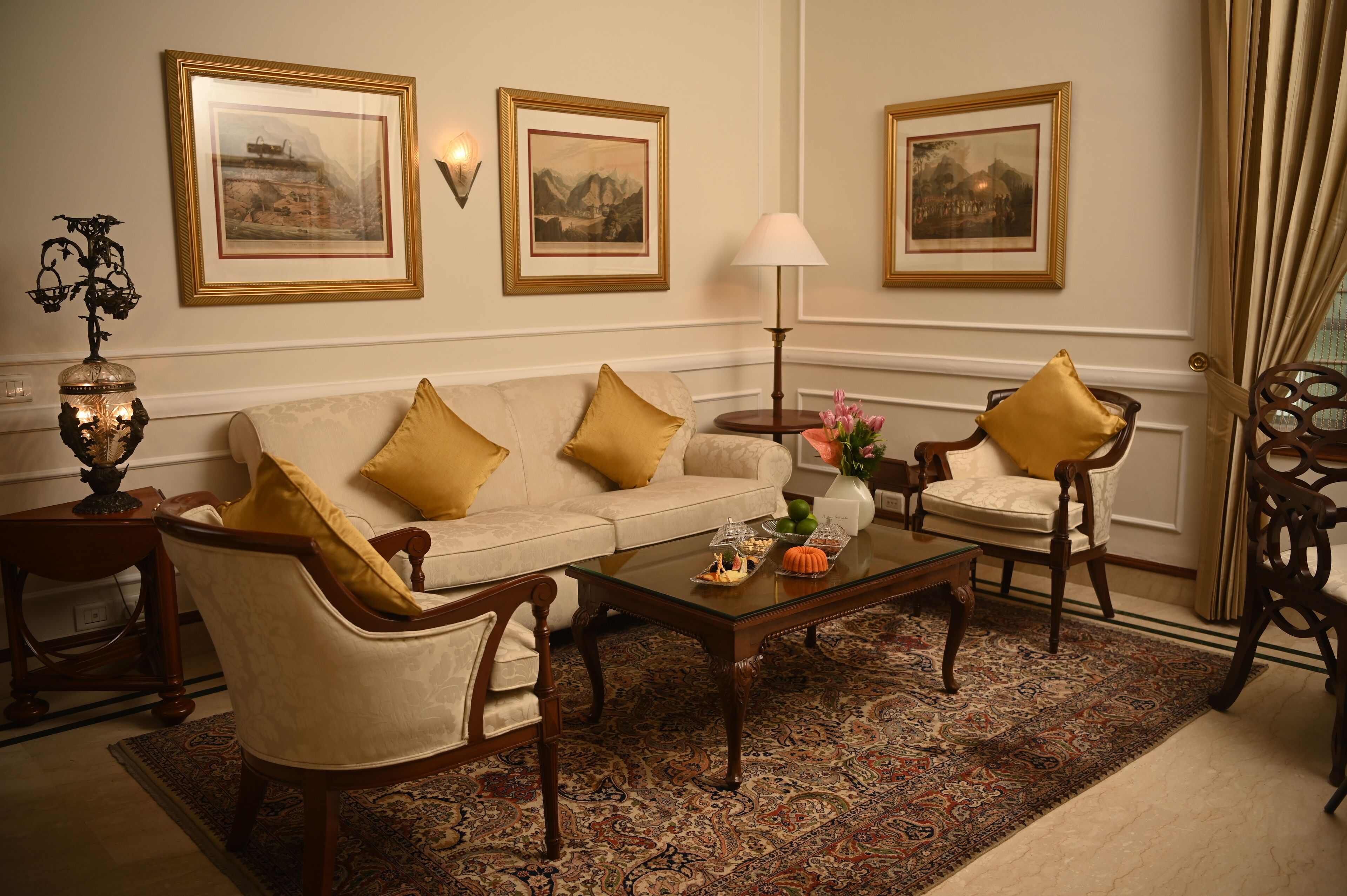 A traditional living room with a sofa, two armchairs, a coffee table, and a patterned rug.