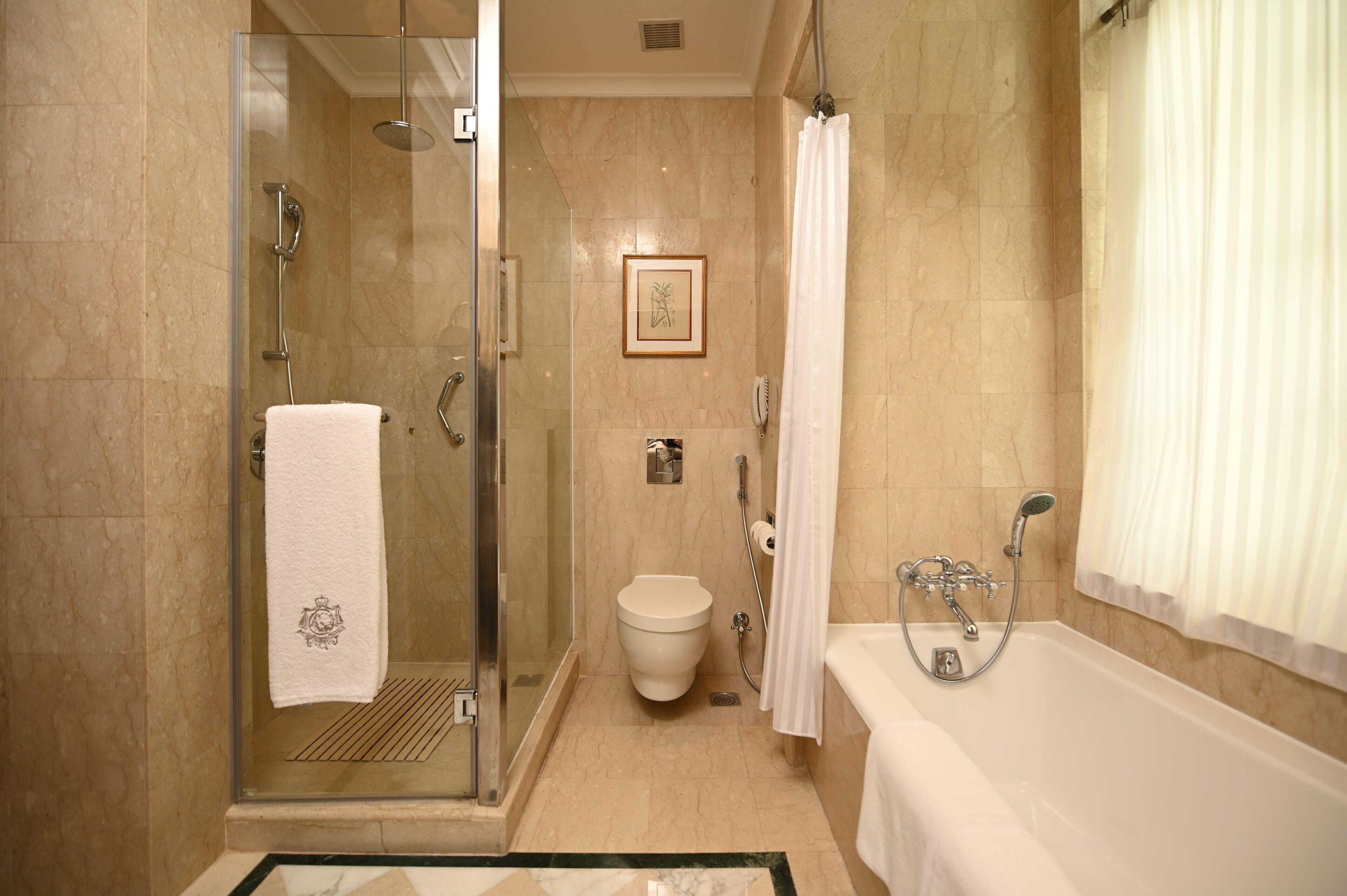 A modern bathroom with a glass-enclosed shower, a toilet, and a bathtub.