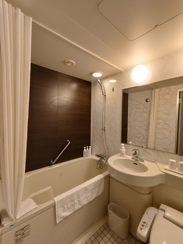 Une salle de bain moderne équipée d’une baignoire, d’une douche, d’un lavabo et de toilettes.