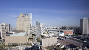 Un quartier urbain moderne, caractérisé par de grands immeubles, une vaste structure en verre et une gare.
