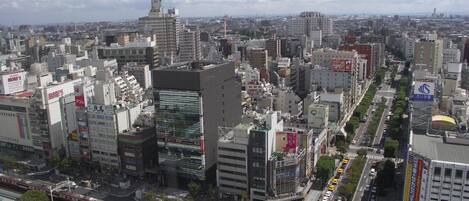 A cityscape with high-rise buildings, a train track, and a busy street.