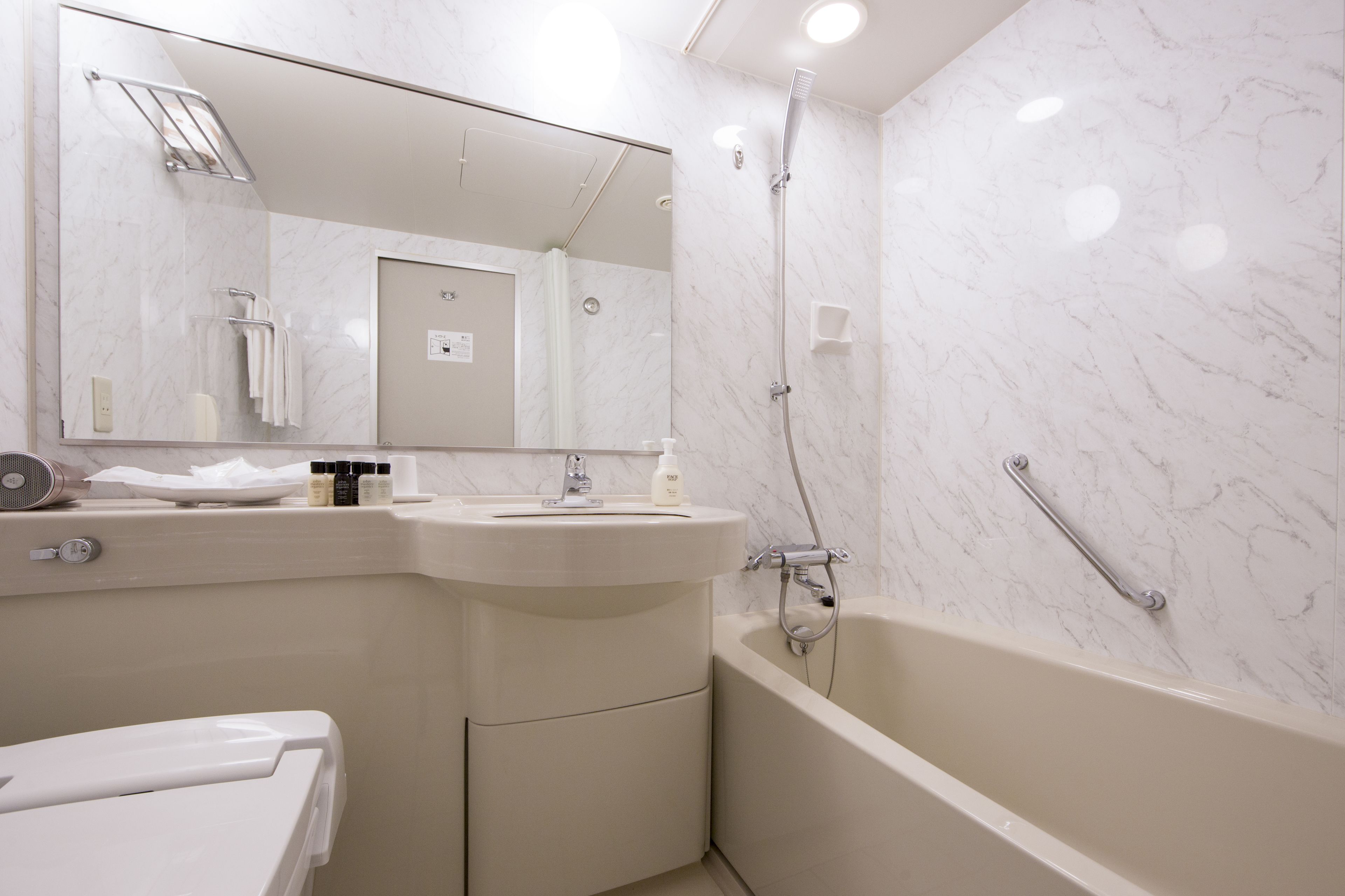 Un baño moderno con lavabo, espejo y bañera.