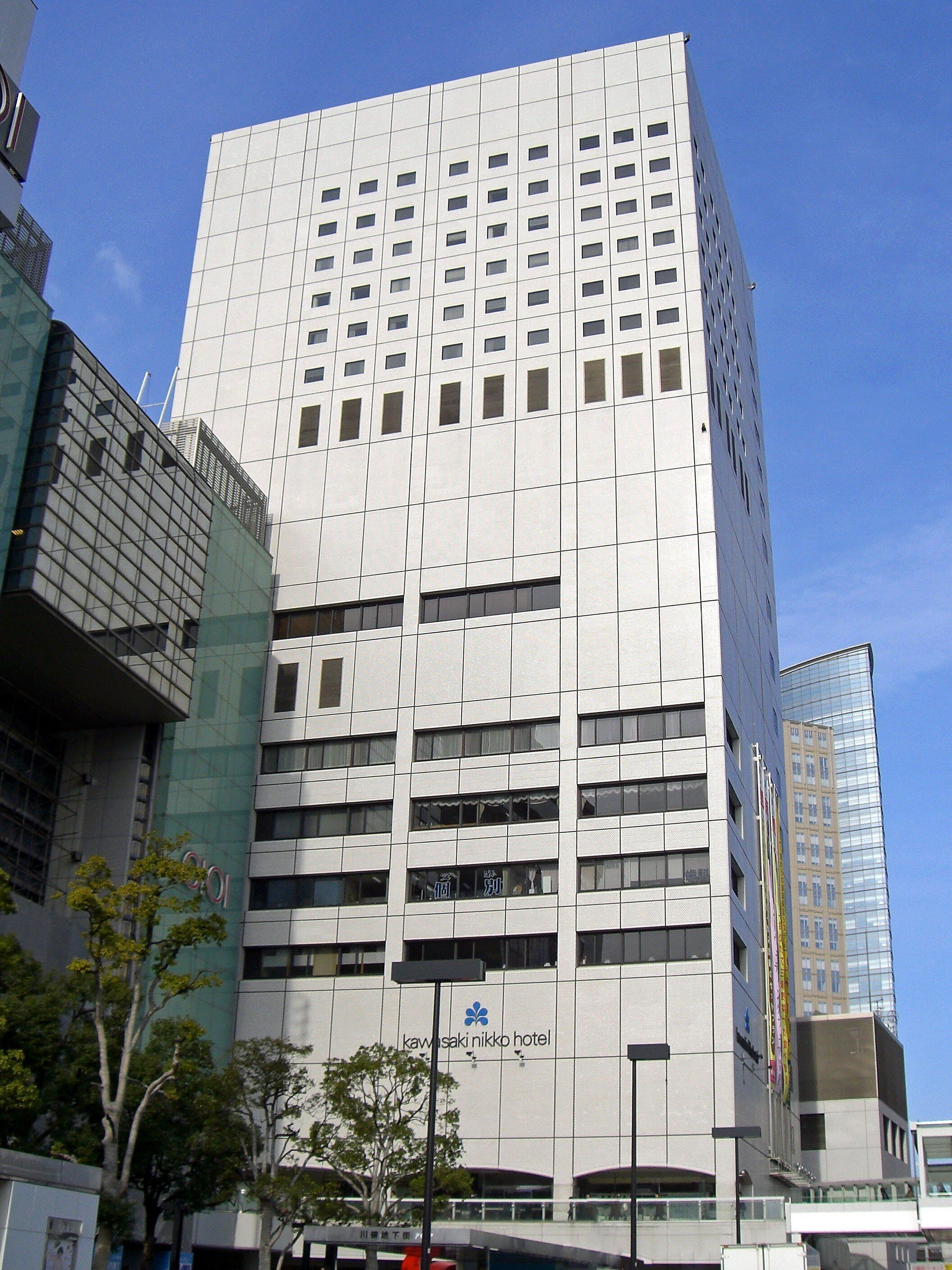 A modern building with a sign for the Kawasaki Nikko Hotel.