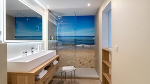 Une salle de bain moderne avec un grand miroir, une baignoire et un espace douche.