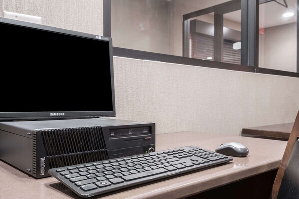 Un monitor Samsung, una torre ThinkCentre, un teclado y un ratón sobre un escritorio en un cubículo.