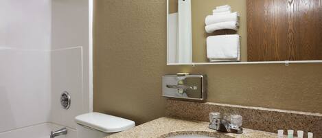 Un baño con bañera, inodoro, lavabo y espejo.
