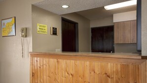 Un espace d’accueil comprenant un comptoir en bois, un téléphone, une carte et un panneau indiquant que l’établissement appartient à Hansde Inc.