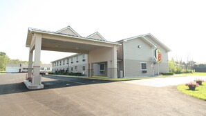 Un motel doté d’un parking couvert, de plusieurs chambres et d’un drapeau sur le bâtiment.