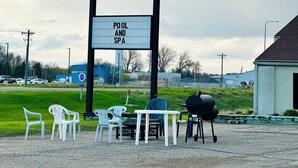 Señal de un motel Super 8 con piscina, spa, zona de estar al aire libre y área de barbacoa.