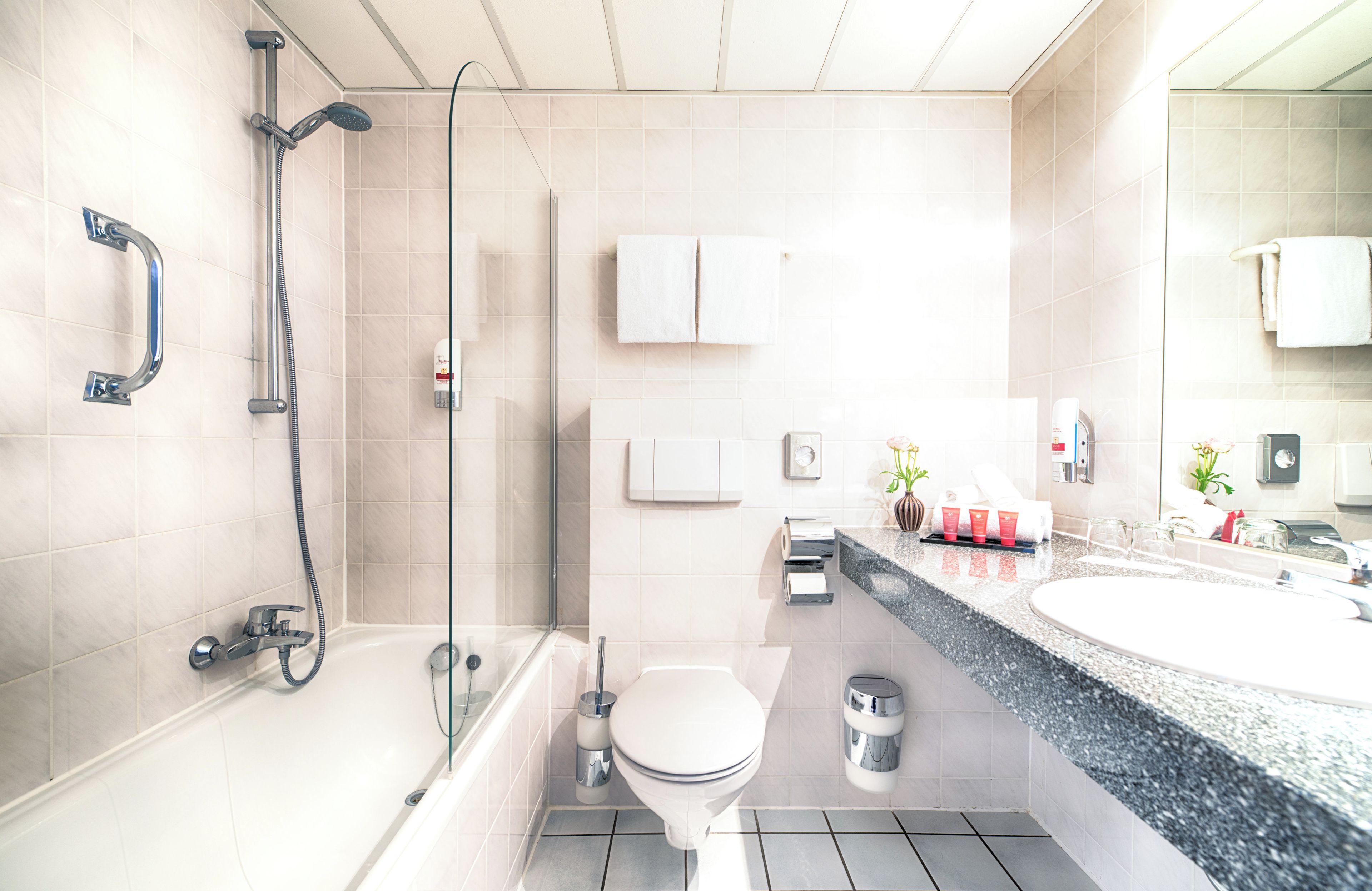 Un baño moderno con bañera, inodoro y zona de ducha.