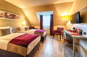 A hotel room with two beds, a desk, a chair, a TV, and a window with curtains. - Leonardo Hotel Mannheim - Ladenburg (Ladenburg)