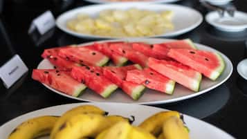 Una mesa de buffet con diversas frutas y platos.