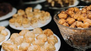 Een buffettafel met diverse gebakjes, waaronder croissants en ander vers gebakken brood.