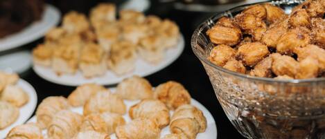 A buffet table with various pastries, including croissants and other baked goods.