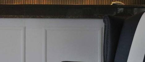 A black and white striped chair in a room with a wooden panel wall and a circular emblem above it.