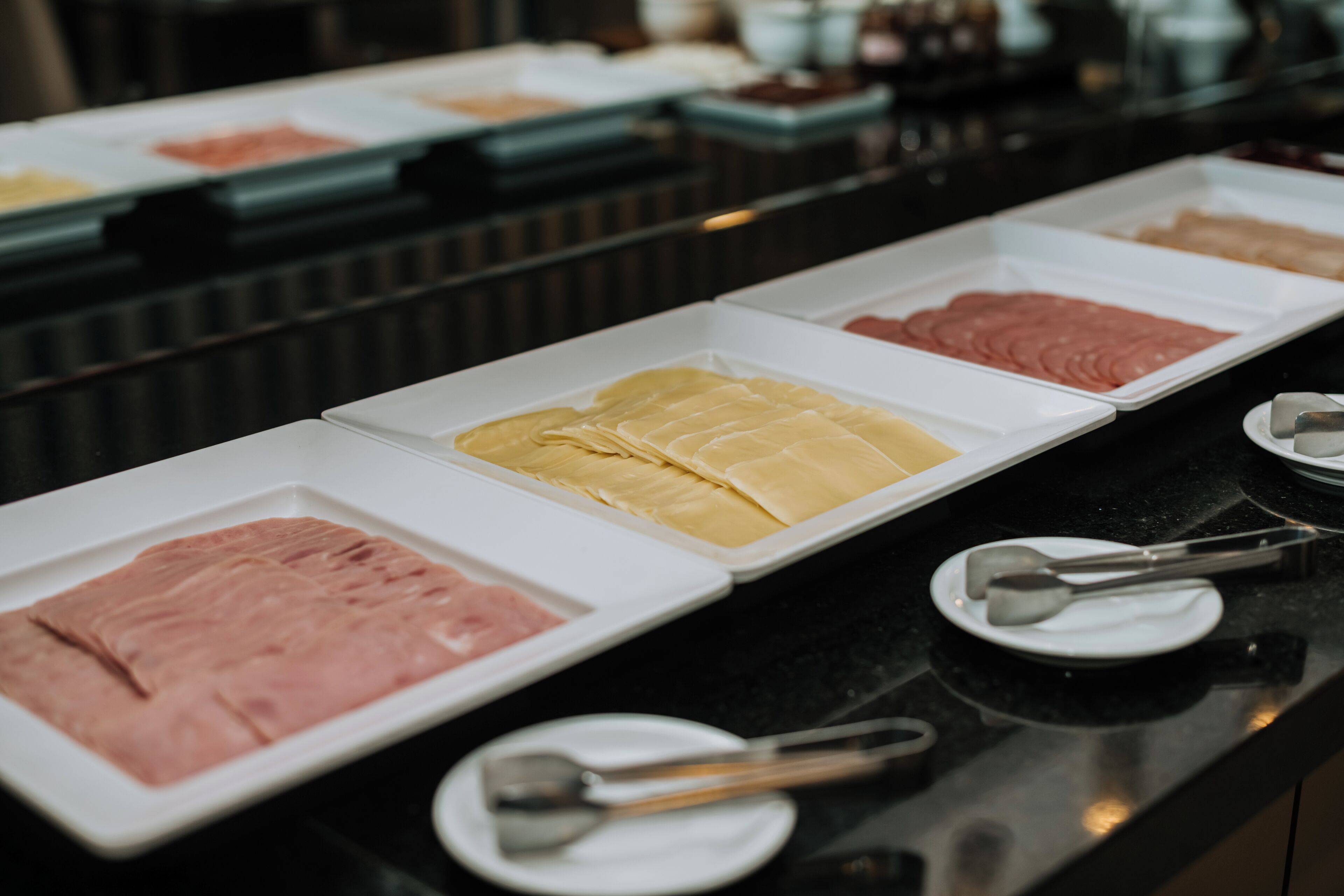 Un buffet proposant une variété de plats présentés dans des plateaux blancs.