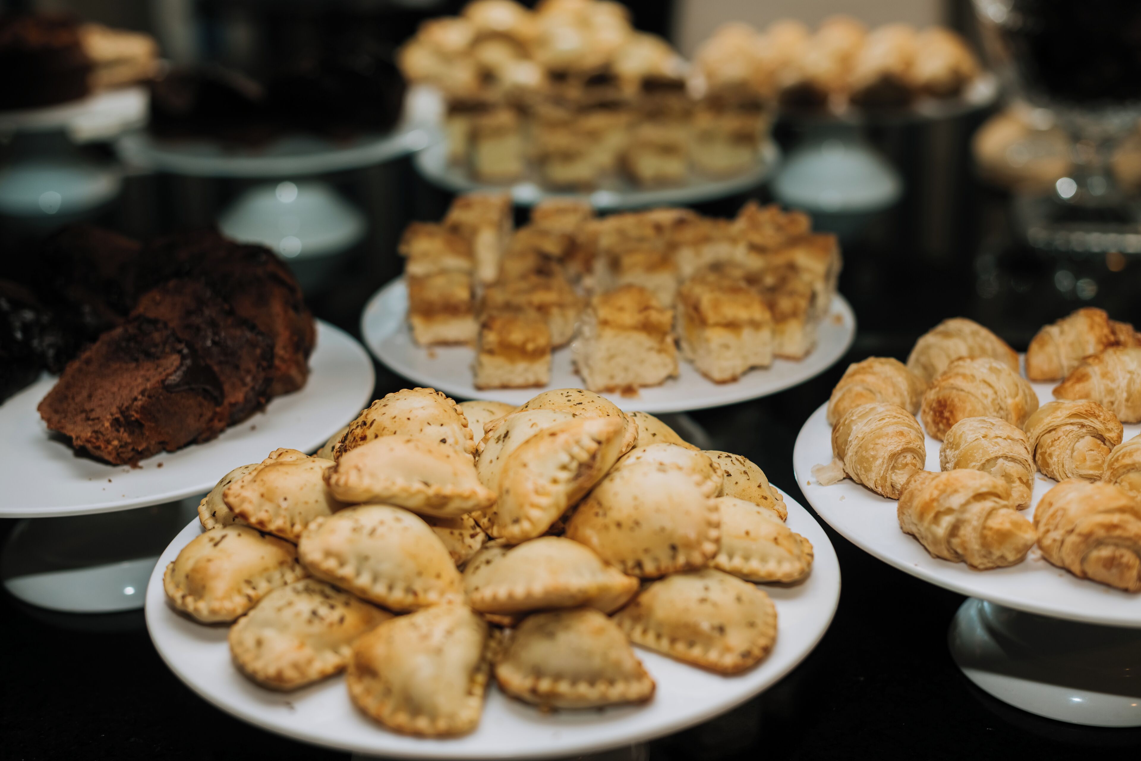 A variety of pastries on plates, including croissants and other baked goods.