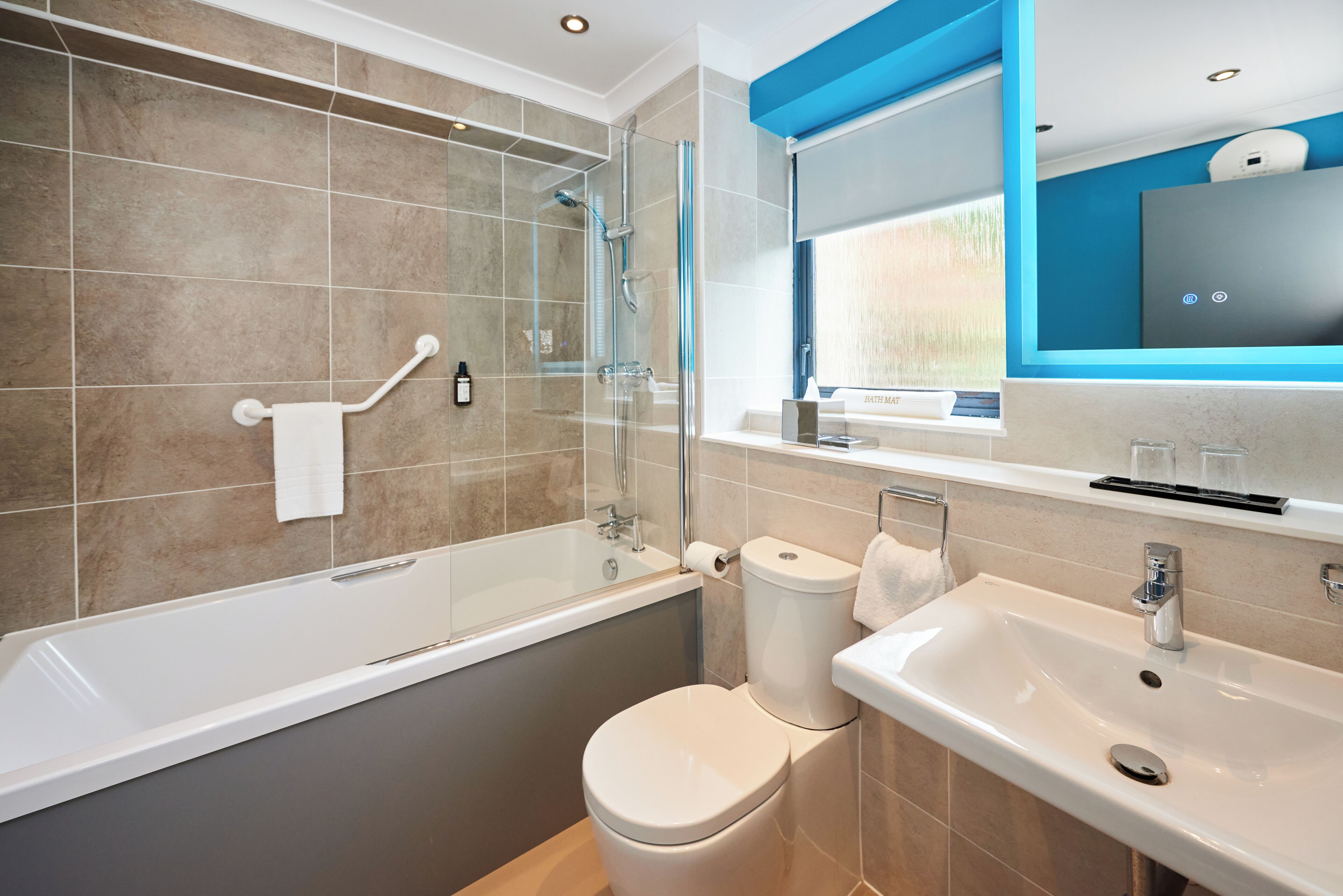 A modern bathroom with a bathtub, toilet, and sink.