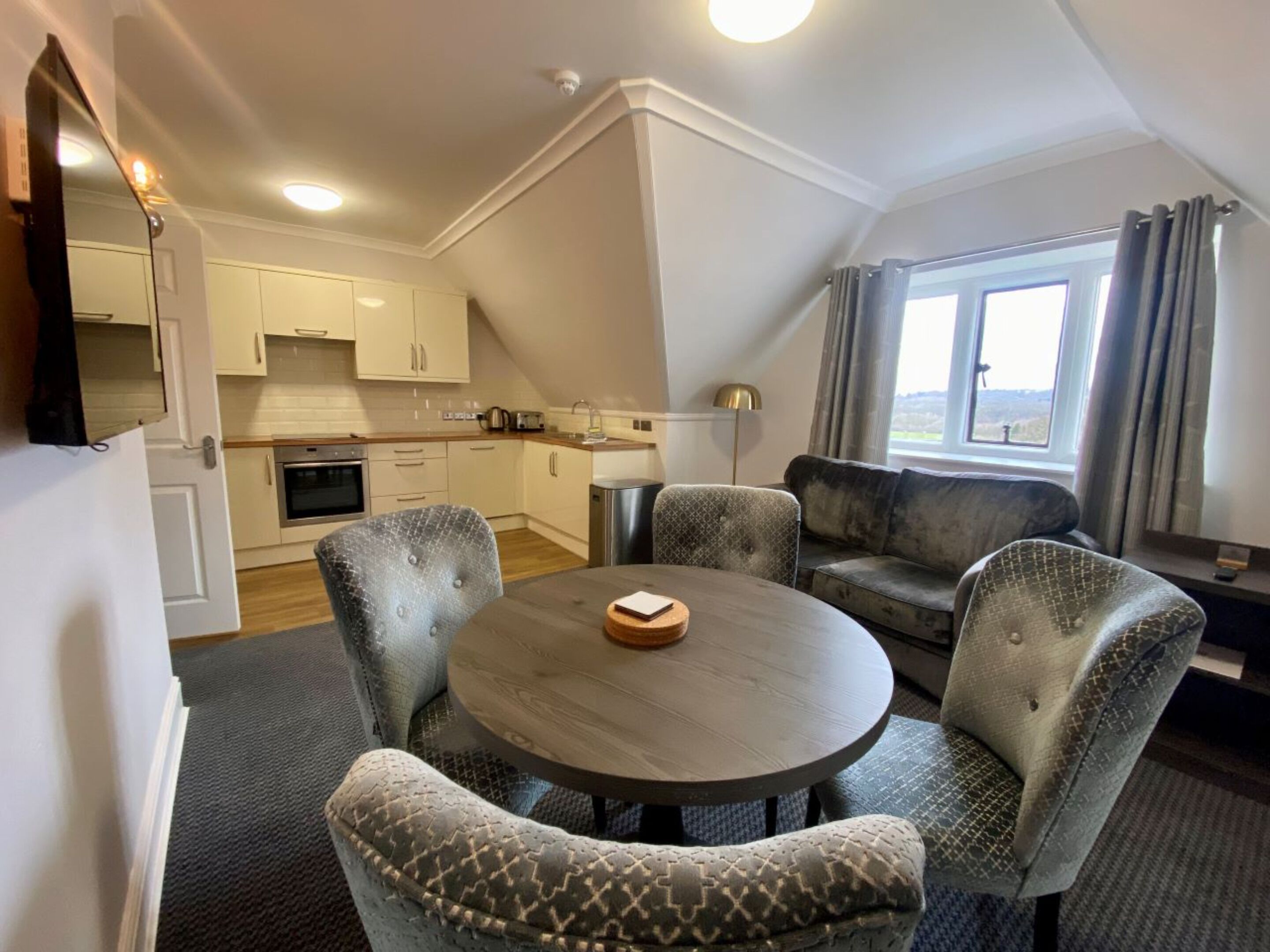 Un espacio habitable compacto con comedor, kitchenette y sofá.