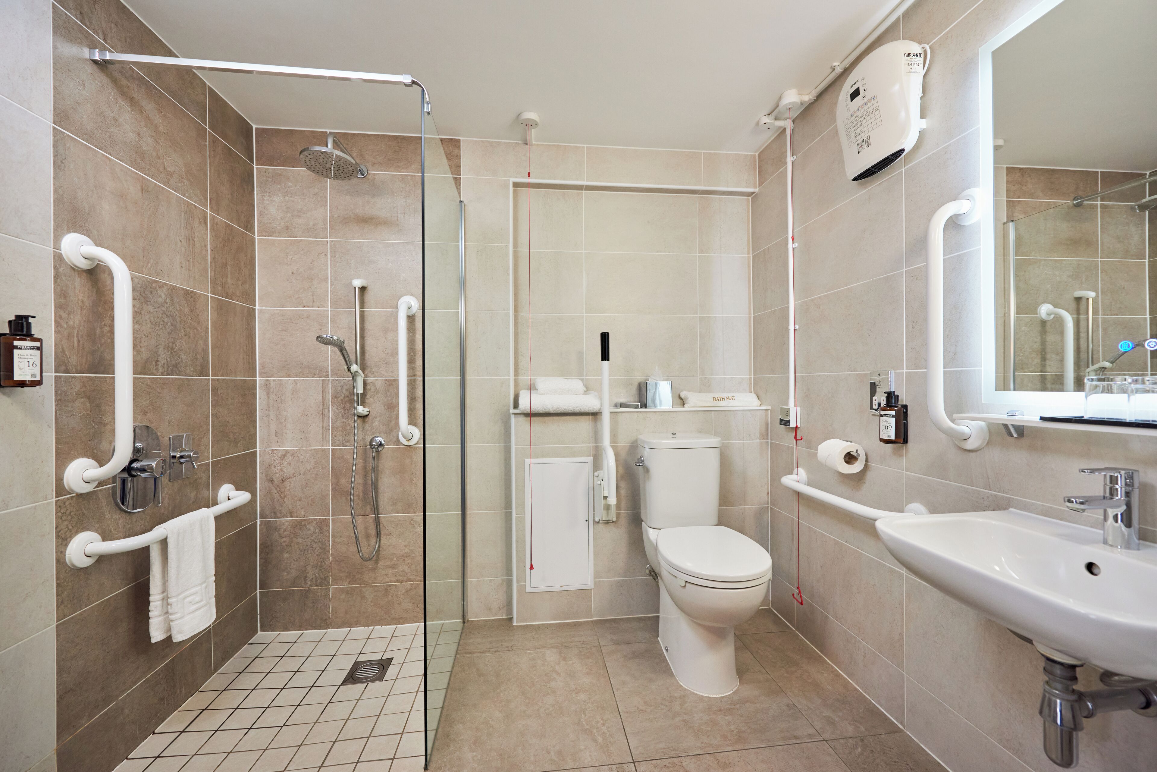 A modern bathroom with a shower, toilet, and sink.