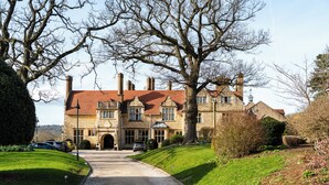 A stone building with a red roof, a driveway, and a well-maintained lawn. - Rutland Hall Hotel & Spa (Oakham)