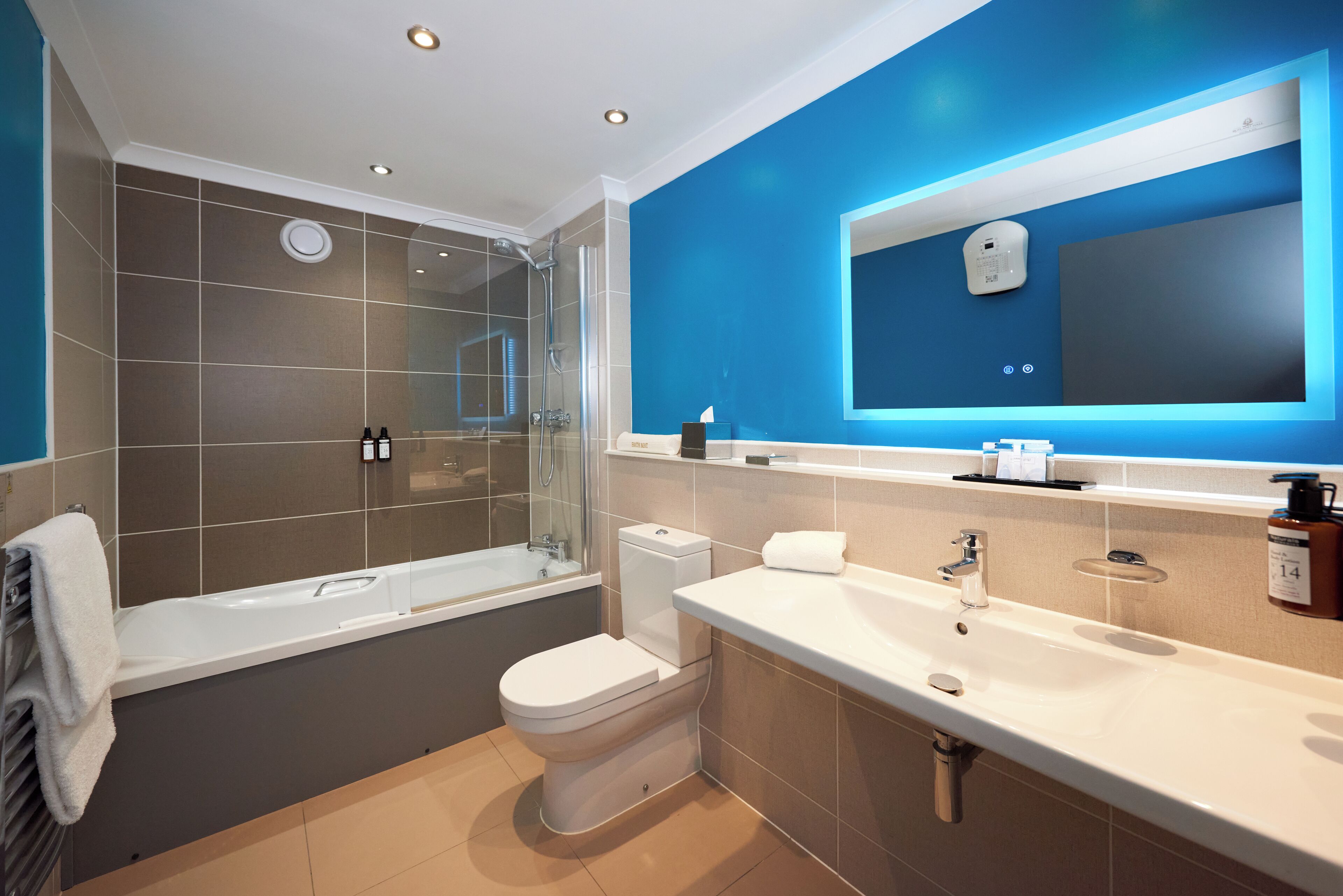 A modern bathroom with a bathtub, toilet, and sink.