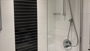 Une salle de bain moderne avec une douche à parois de verre, une baignoire blanche et des carreaux de marbre noir.