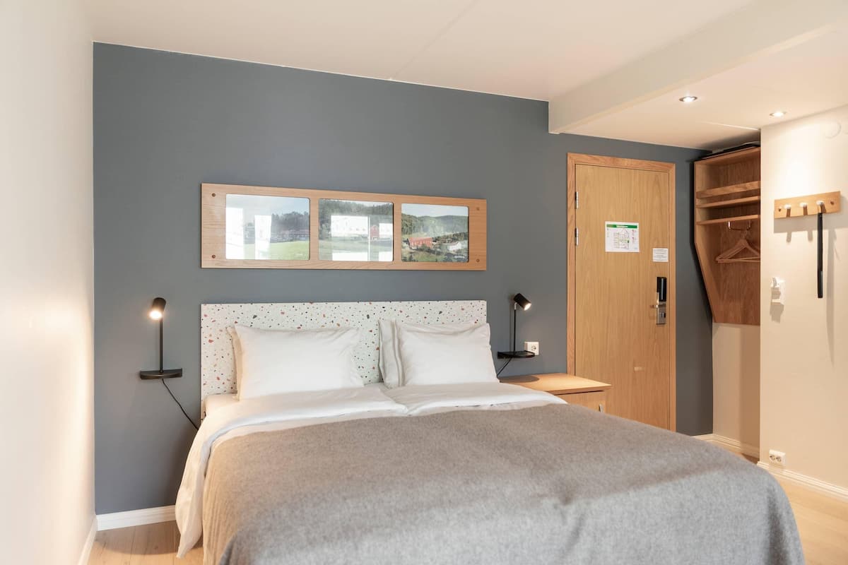 A bedroom with a bed, bedside tables, a wardrobe, and a framed picture on the wall.