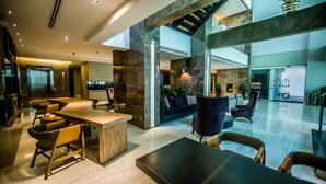 A spacious lobby with a high ceiling, marble walls, and a central seating area with a bar. - Mercure Uberlândia Plaza Shopping (Uberlandia)