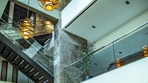 A spacious lobby with a high ceiling, a staircase, and modern lighting fixtures. - Mercure Uberlândia Plaza Shopping (Uberlandia)