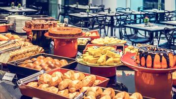A buffet with various baked goods and pastries.