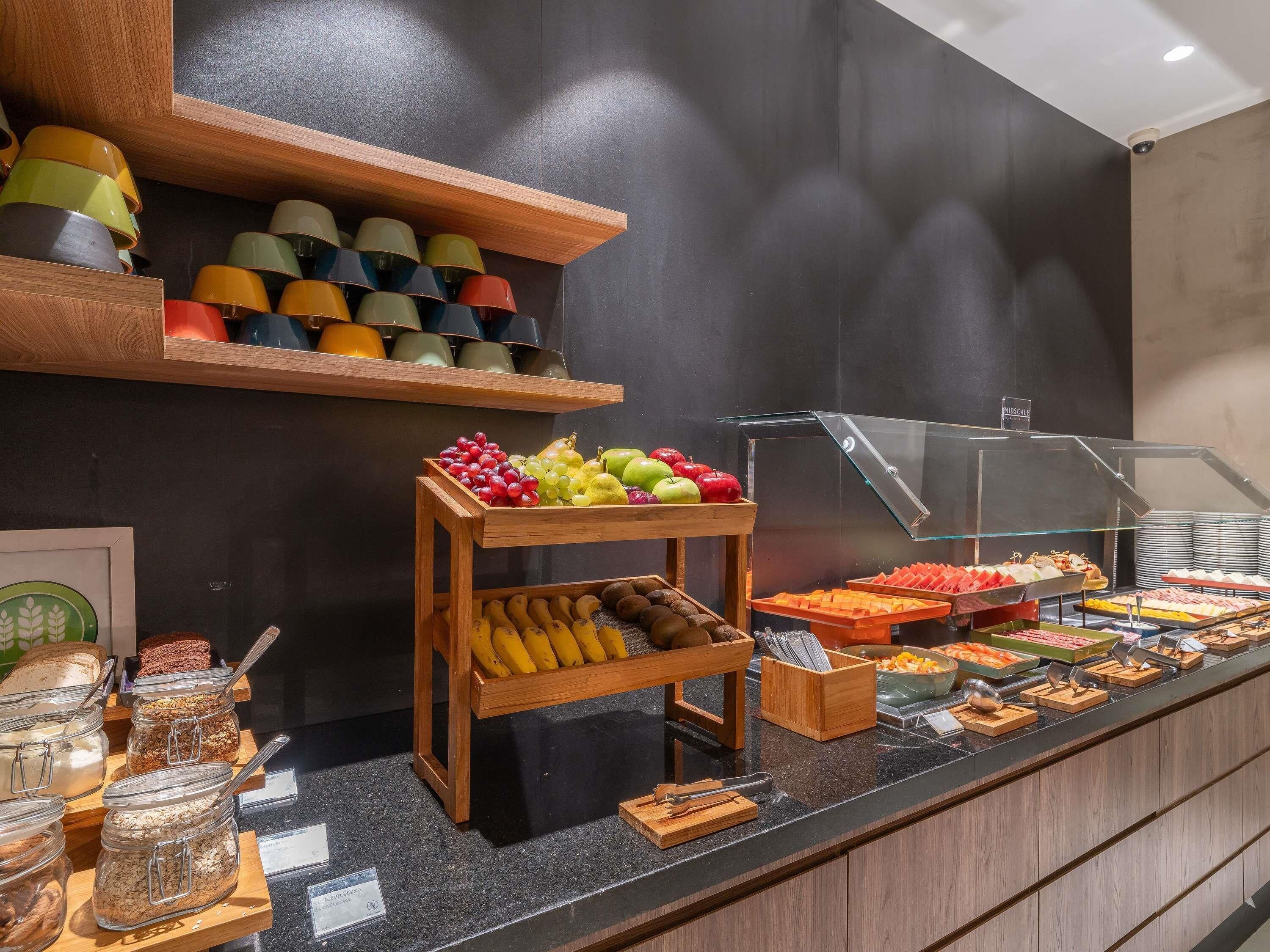 A buffet area with various food items, including fruits, vegetables, and prepared dishes.
