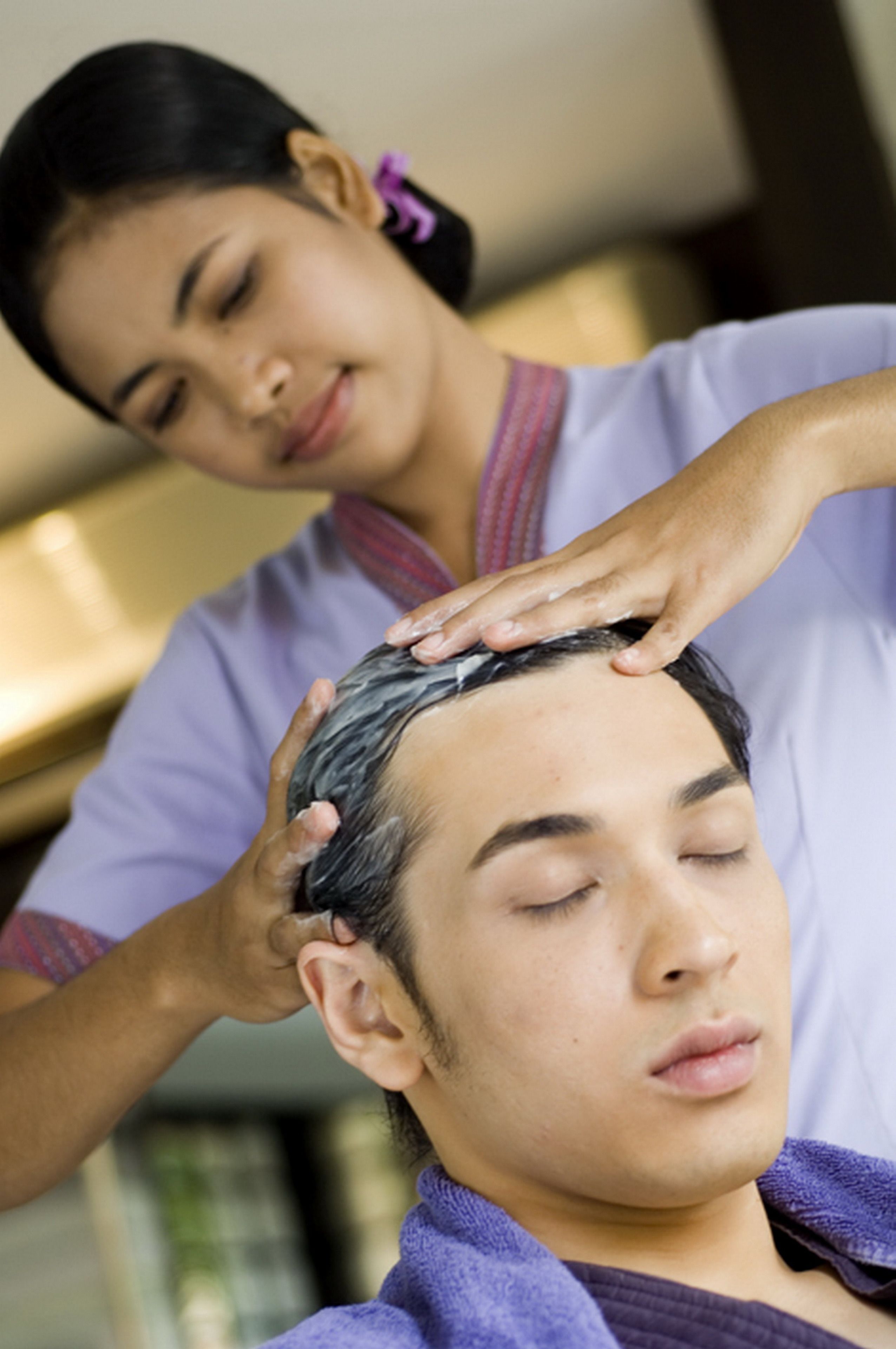 A person receiving a head massage.