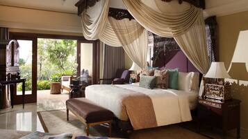 A four-poster bed with a canopy, a bench, a nightstand with a lamp, and a view of the outdoors.