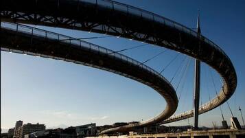 Un grand pont incurvé enjambant une étendue d’eau, avec des bâtiments en arrière-plan.