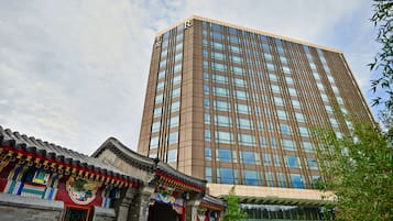 A modern high-rise building with a traditional architectural style in the foreground.
