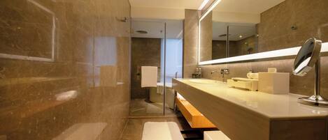 A modern bathroom with a large mirror, a sink, and a shower area.