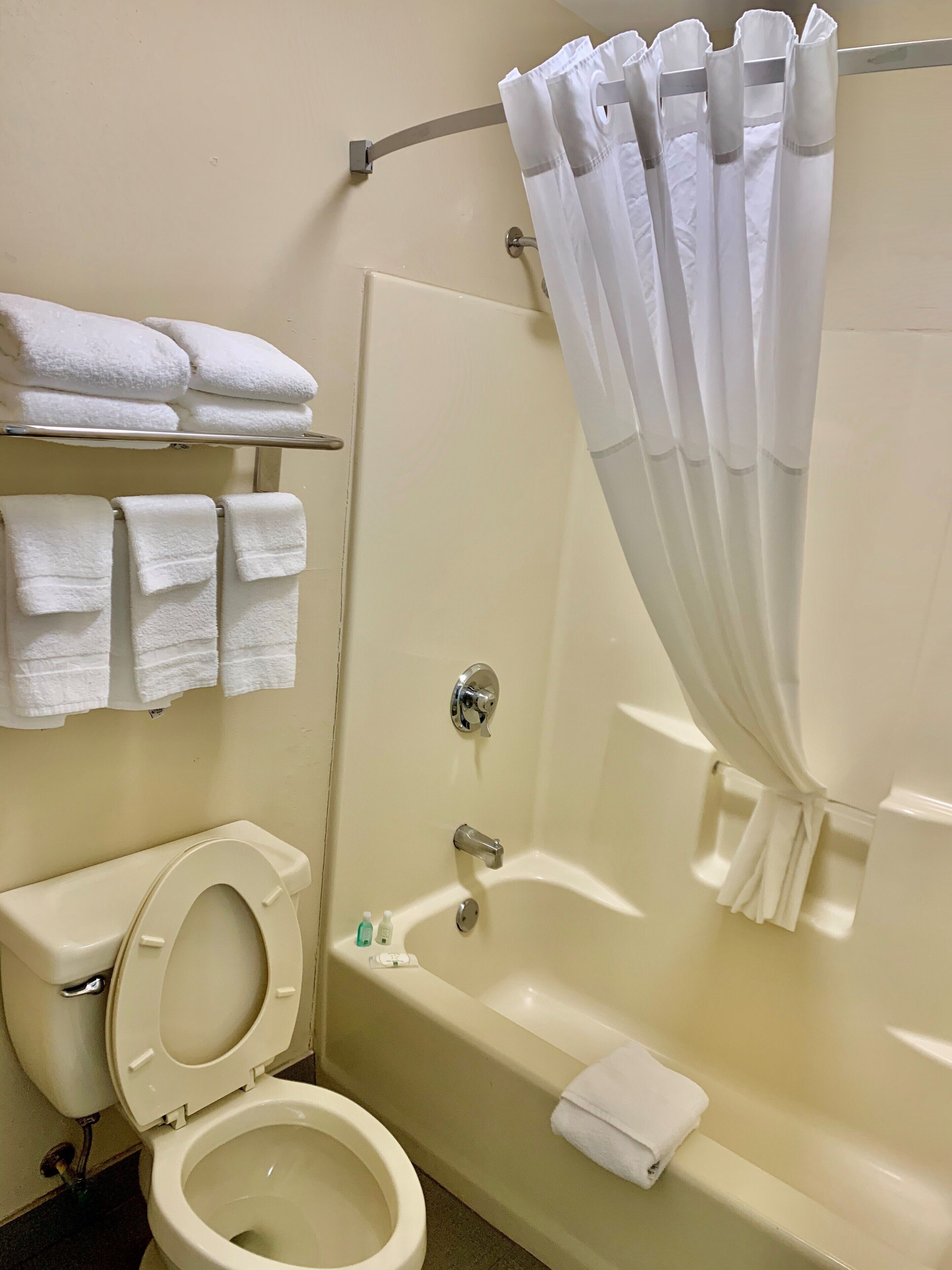 Un baño con inodoro, bañera y cortina de ducha.