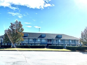 Stunning hotel with a symmetrical facade, surrounded by a lush lawn and mature trees.