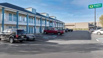 Un motel con edificios de varios pisos, un estacionamiento con varios autos y un letrero de Quality Inn by Choice Hotels.