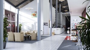 A spacious lobby with high ceilings, large windows, and a reception desk. - Scandic Sønderborg (Sønderborg)