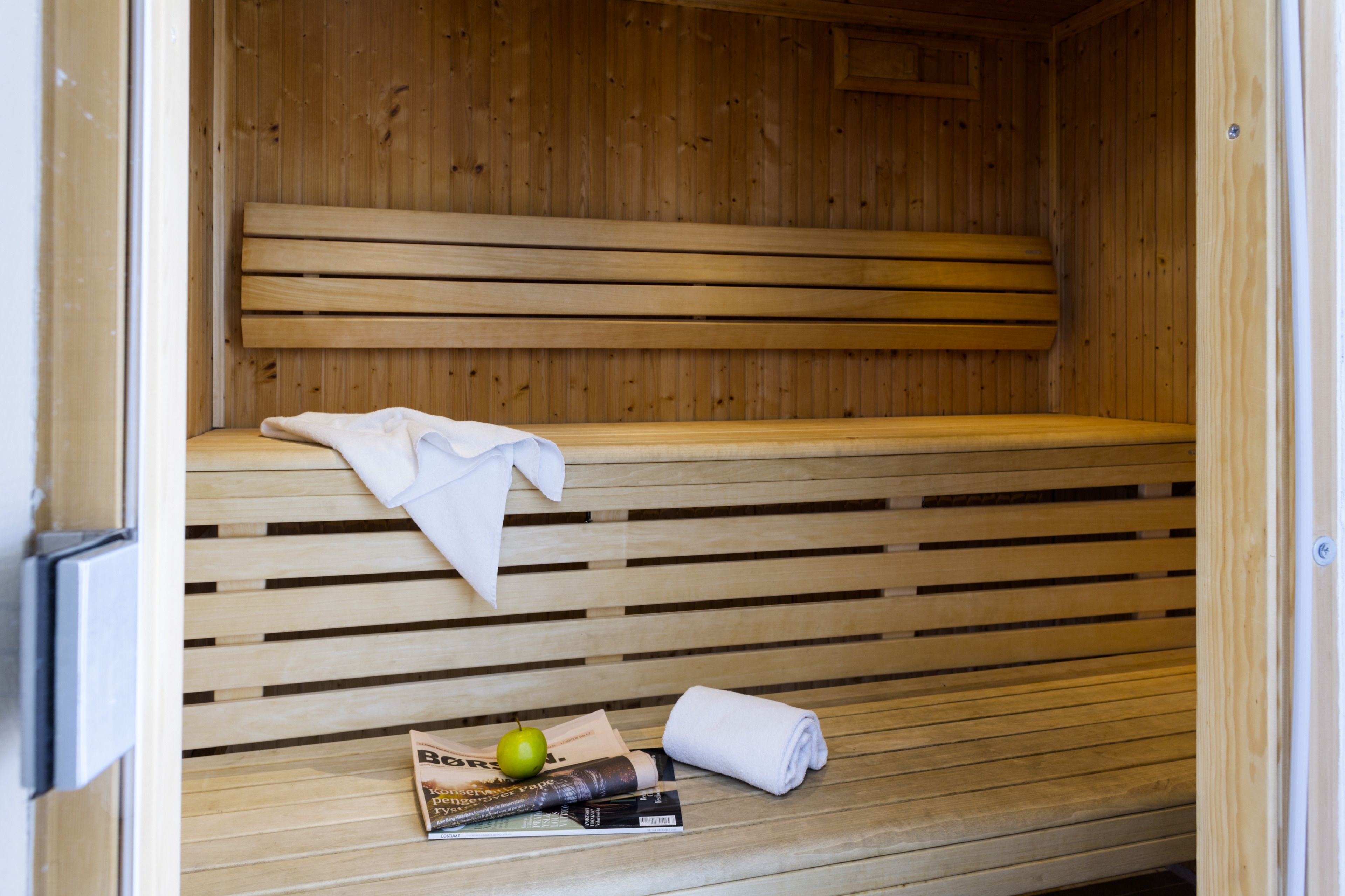 Un banco de sauna de madera con una toalla y una manzana verde encima.