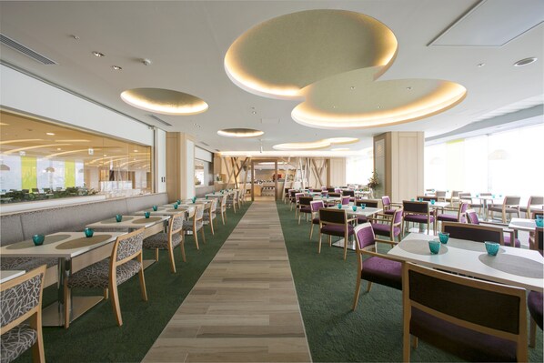 A spacious dining area with multiple tables and chairs, a central aisle, and a long counter with a menu display. - Hotel Granvia Hiroshima (Hiroshima)