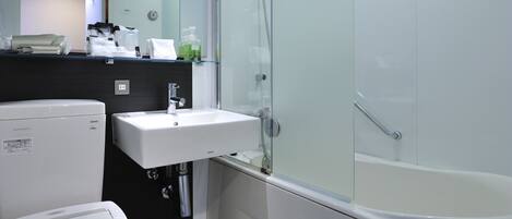 A modern bathroom with a toilet, sink, and glass-enclosed shower.